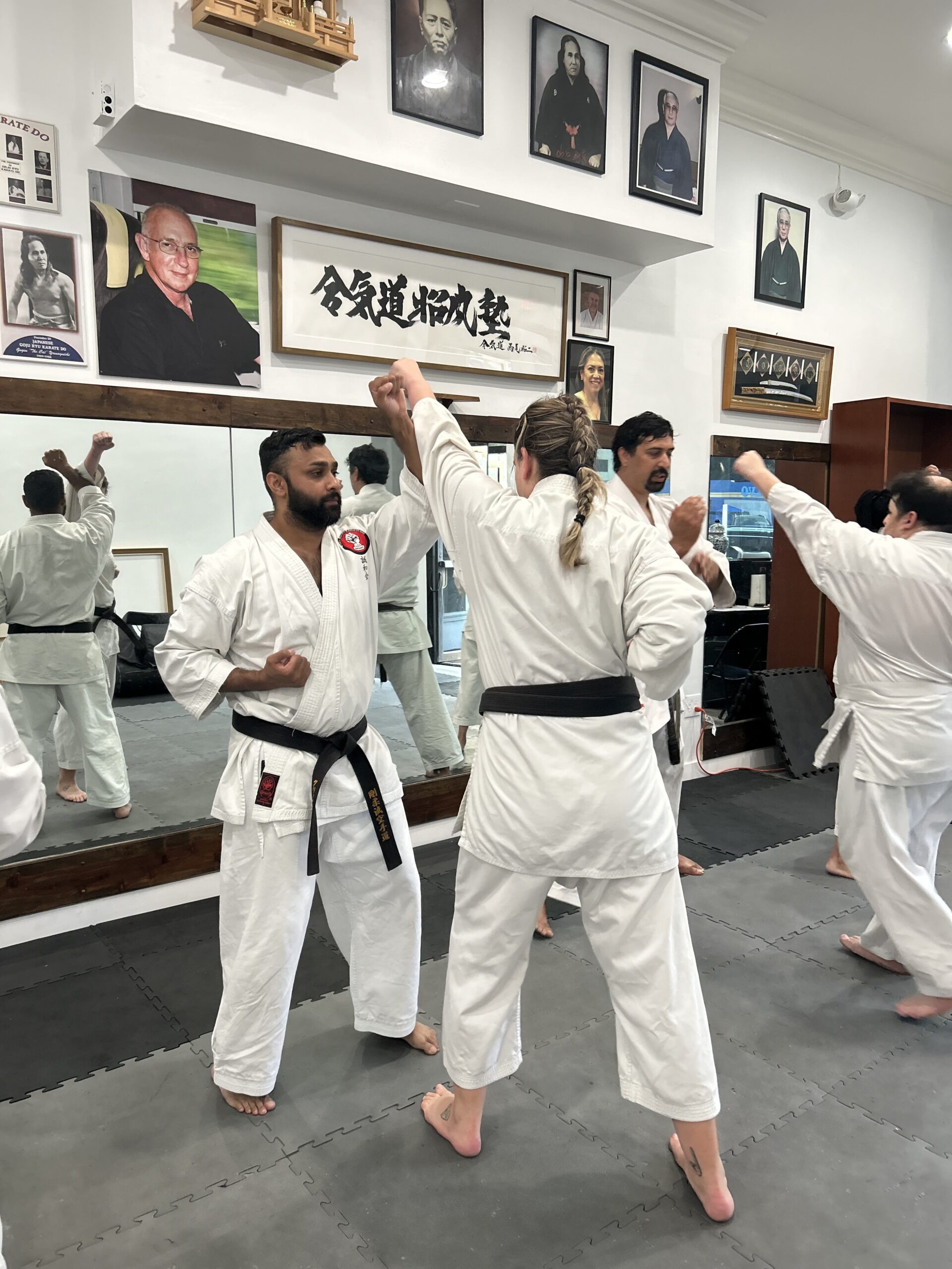 Black belts engaged in traditional karate training during a live kumite sparring drill at our West LA dojo.