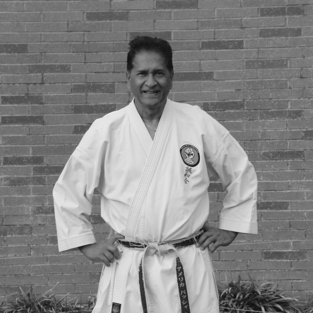 shihan-vassie-naidoo-8th-dan-karate-los-angeles Shihan Vassie Naidoo, 8th Dan and Vice President of Siewa-Kai International, in a traditional karate gi standing in front of a brick wall near the Karate of LA dojo in West Los Angeles.