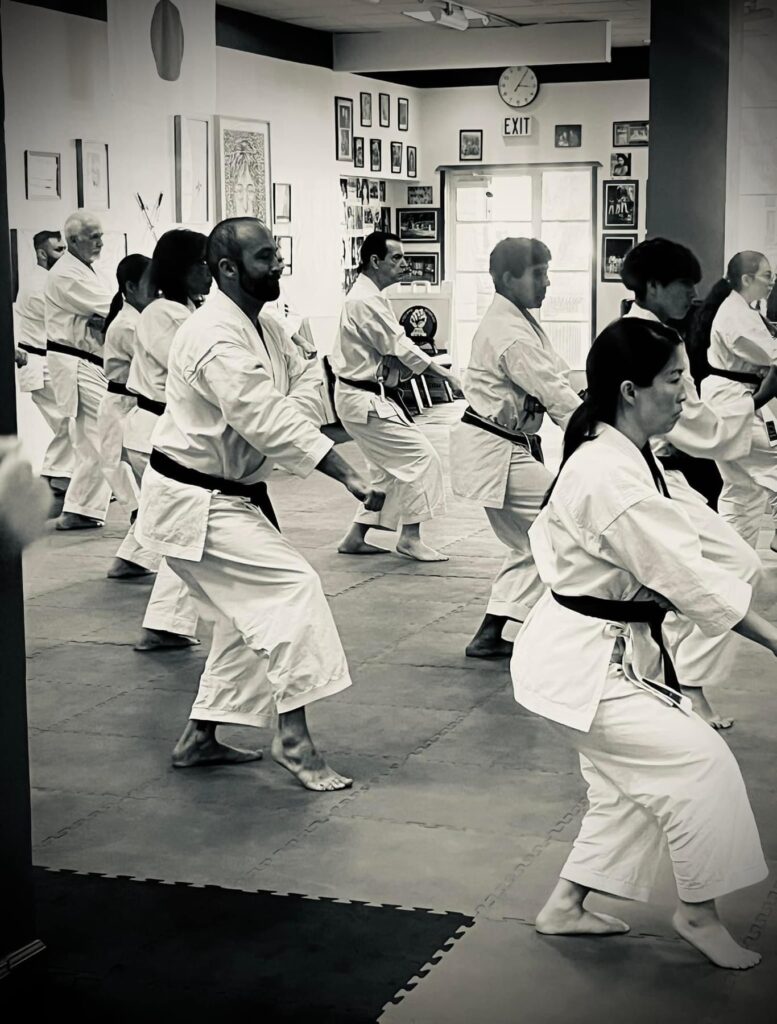 A black and white photo showing a group of karate students practicing kata at the Pan American Seiwakai Seminar and Shinsa